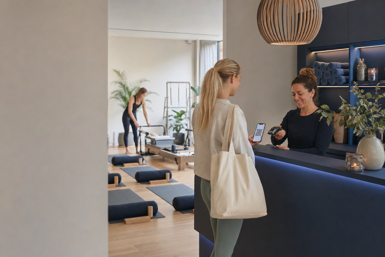 Wellness studio member checking in by QR while an instructor prepares the class